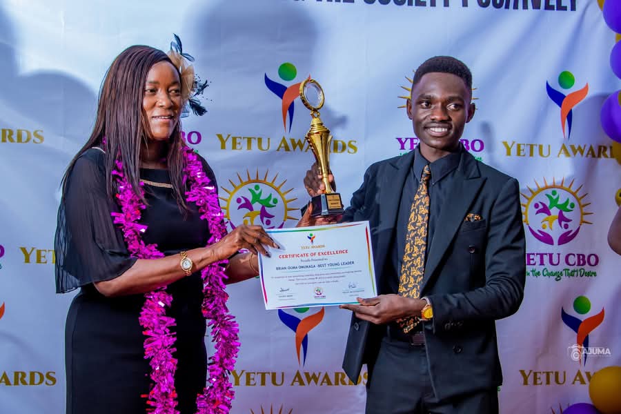 Brian Omukaga receiving the Best Young Leader certificate and trophy at the awards ceremony